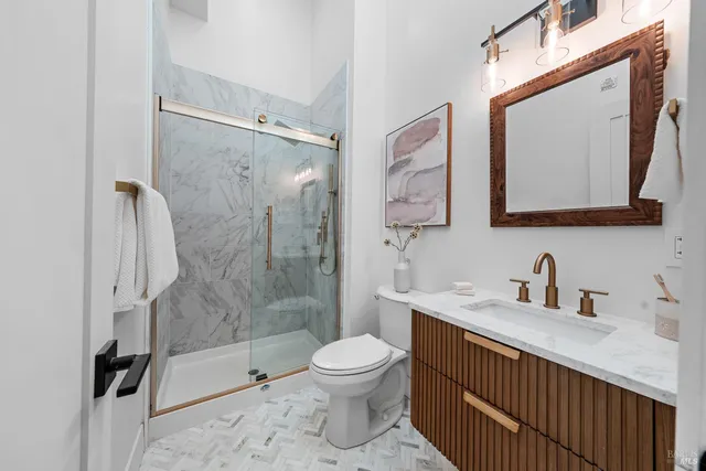 a bathroom with a toilet sink a shower and a mirror