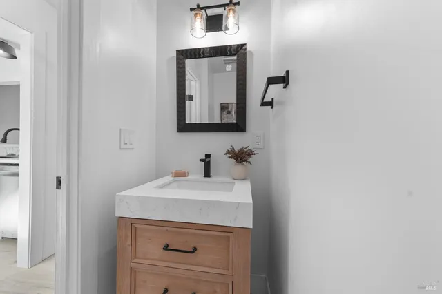 a bathroom with a sink vanity and a mirror