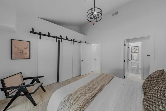 a bedroom with a bed and a chandelier