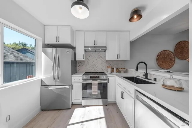 a kitchen with a sink a counter and chairs