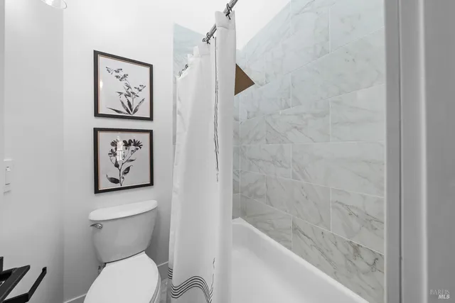 a bathroom with a toilet and a shower