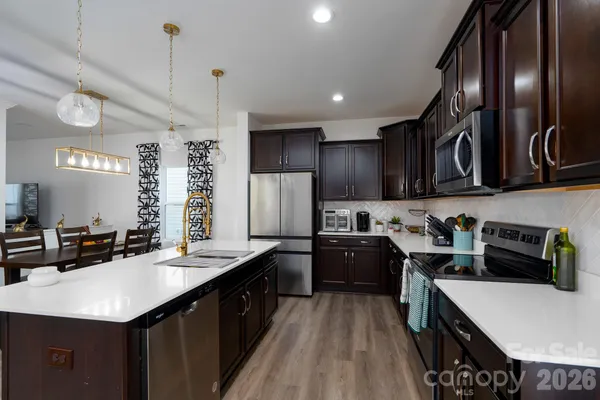 a kitchen with a sink a stove cabinets and wooden floor