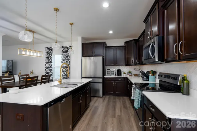 a kitchen with a sink a stove cabinets and wooden floor