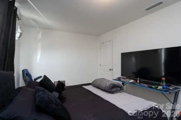 a bedroom with bed and a flat screen tv