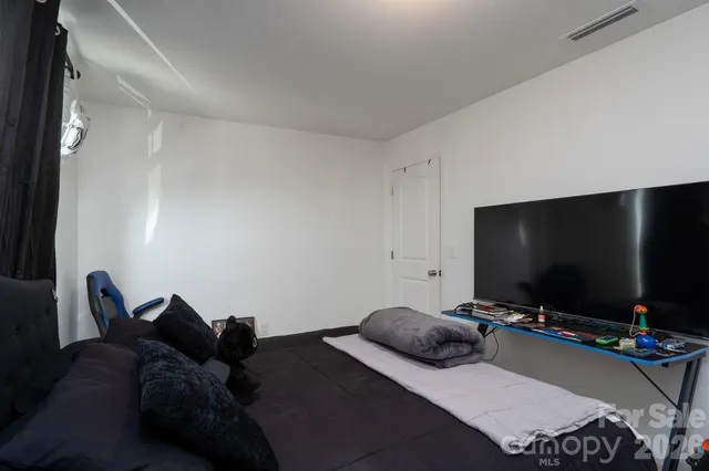 a bedroom with bed and a flat screen tv