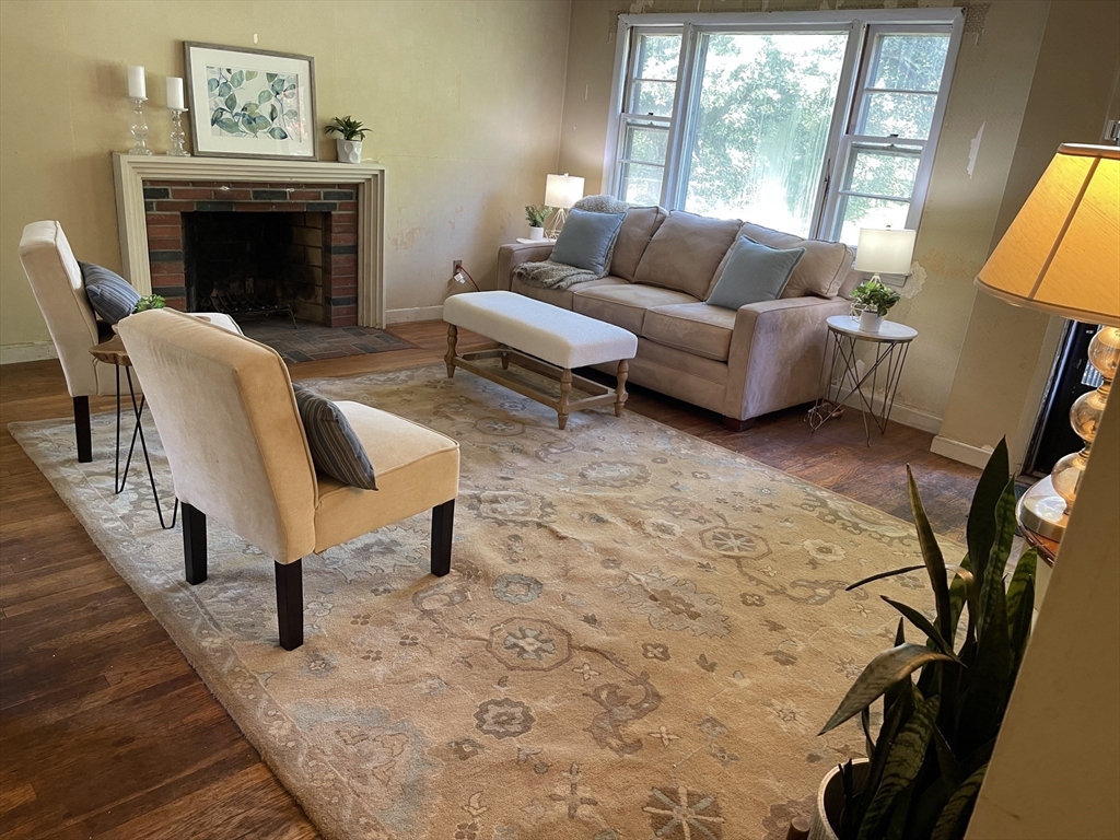 5 Brookfield Road Andover, MA 01810 - Photo 5 of 17 a living room with furniture a fireplace and a floor to ceiling window