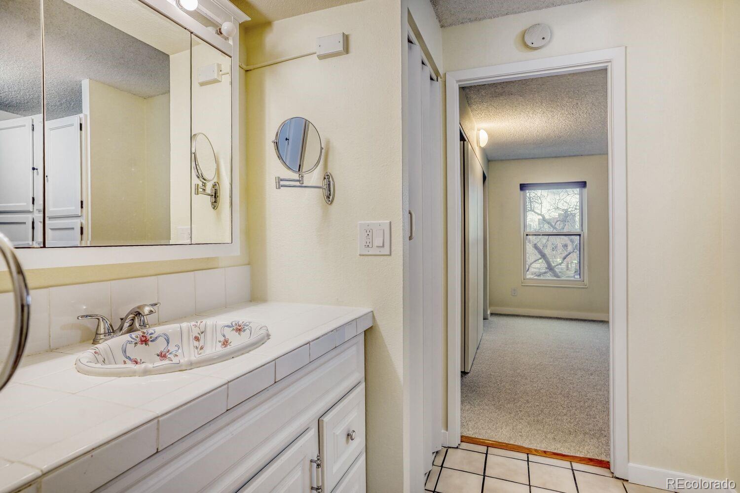 2 Adams Street, Unit 303 Denver, CO 80206 - Photo 13 of 14 a bathroom with a sink and a mirror