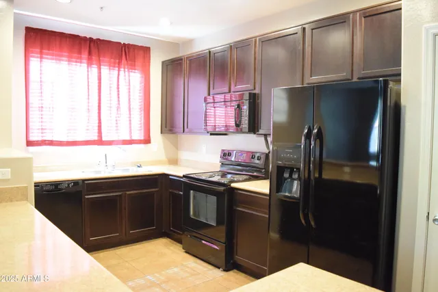 a kitchen with a sink a refrigerator and cabinets
