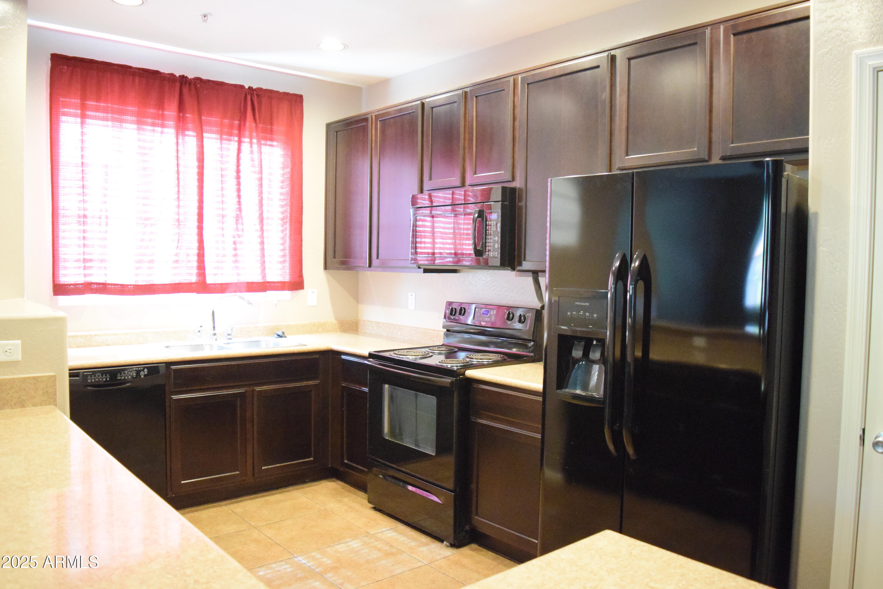 1250 South Rialto, Unit 24 Mesa, AZ 85209 - Photo 6 of 25 a kitchen with a sink a refrigerator and cabinets