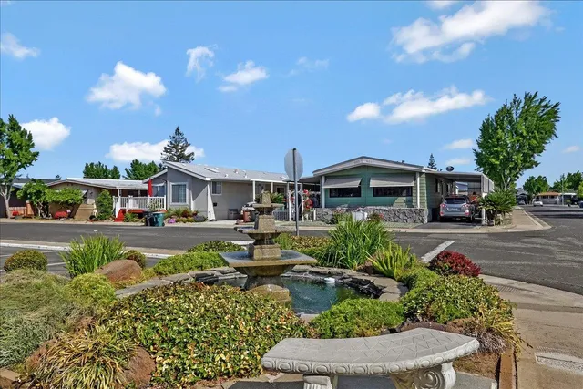 a front view of a house with garden swimming pool and outdoor seating