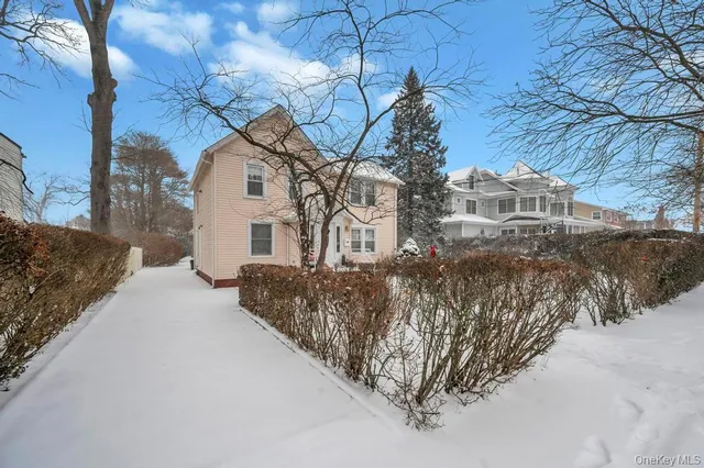 a front view of a house with a yard covered with snow