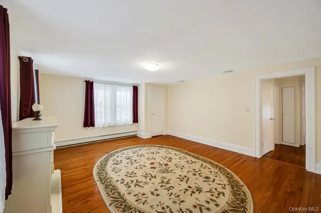 a view of a bedroom with wooden floor and bathroom