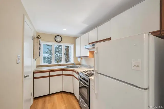 a kitchen with a refrigerator a stove and a window
