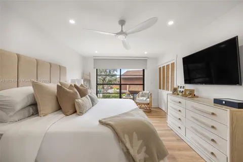 a bedroom with a large bed and a flat screen tv