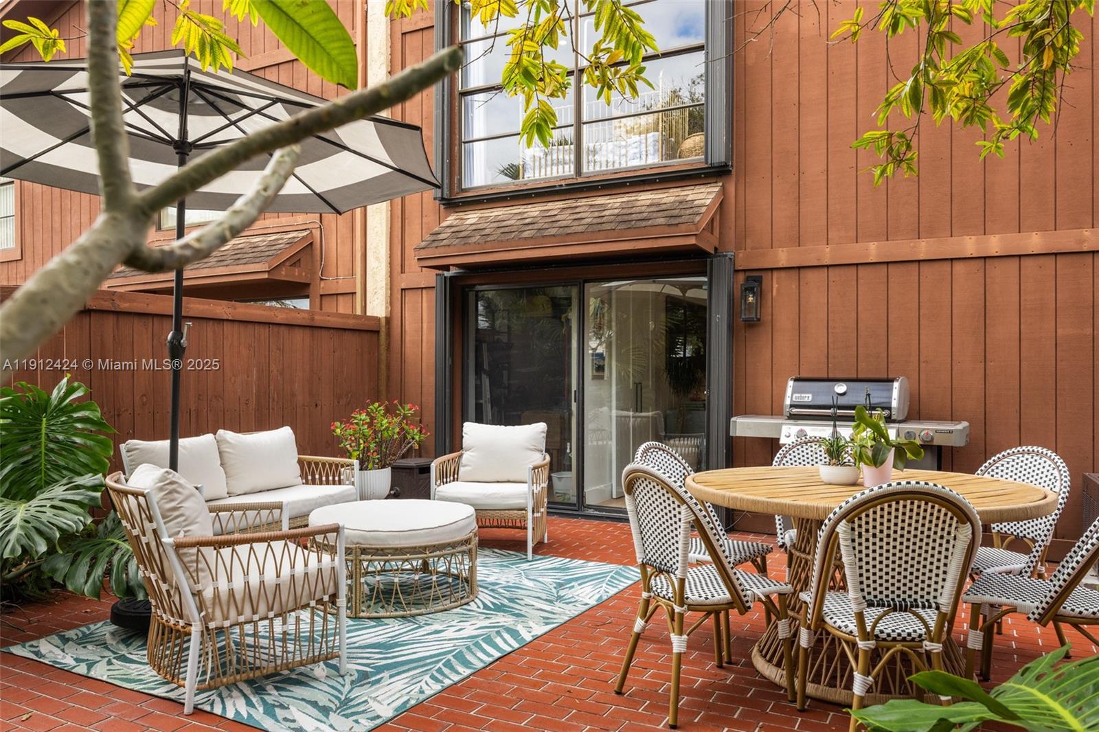 11537 Southwest 64th Street, Unit A83 Miami, FL 33173 - Photo 18 of 24 a view of a patio with a table and chairs