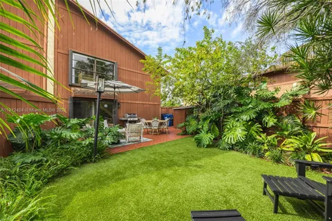a view of a chair and table in backyard of the house