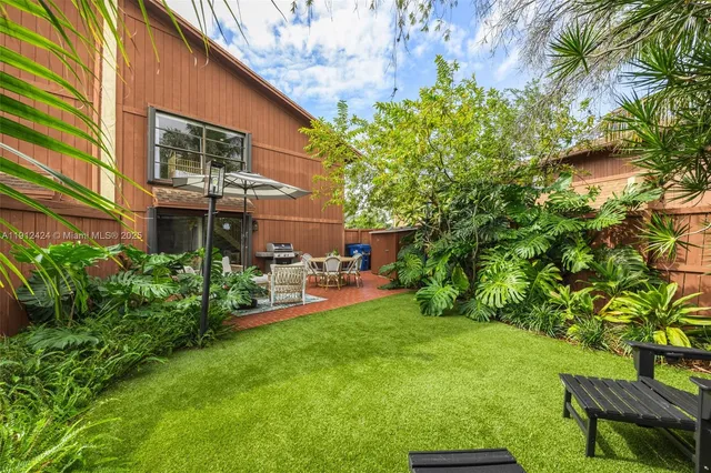 a view of a chair and table in backyard of the house
