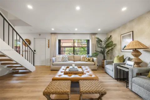 a living room with furniture fireplace and a large window