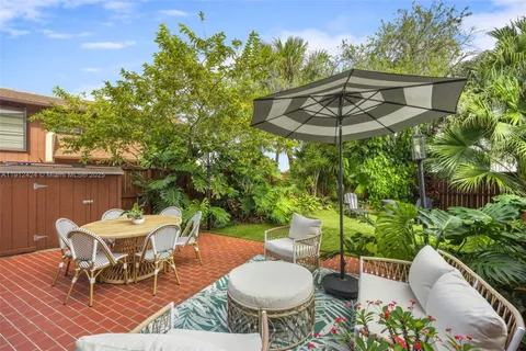 a view of a patio with table and chairs potted plants with wooden floor
