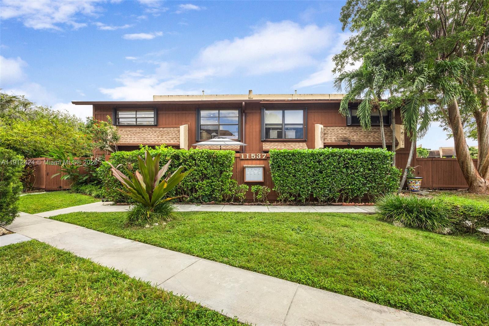 11537 Southwest 64th Street, Unit A83 Miami, FL 33173 - Photo 23 of 24 a front view of a house with a yard