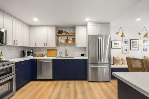a kitchen with stainless steel appliances granite countertop a refrigerator and a stove top oven
