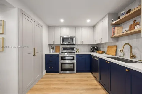 a kitchen with stainless steel appliances granite countertop a stove top oven a sink and dishwasher