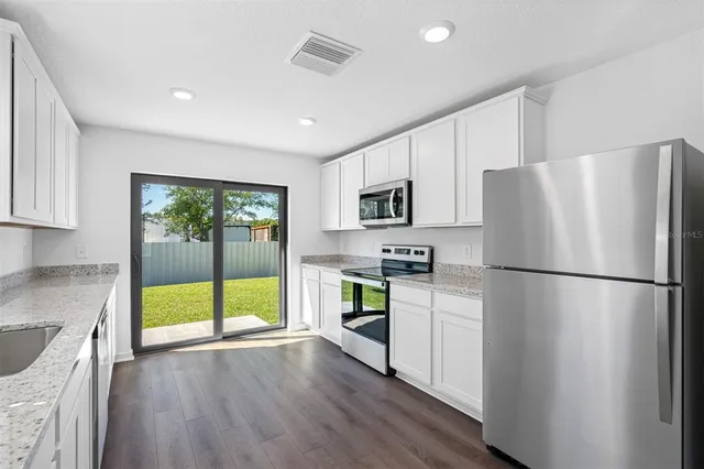 a kitchen with stainless steel appliances a refrigerator sink and microwave