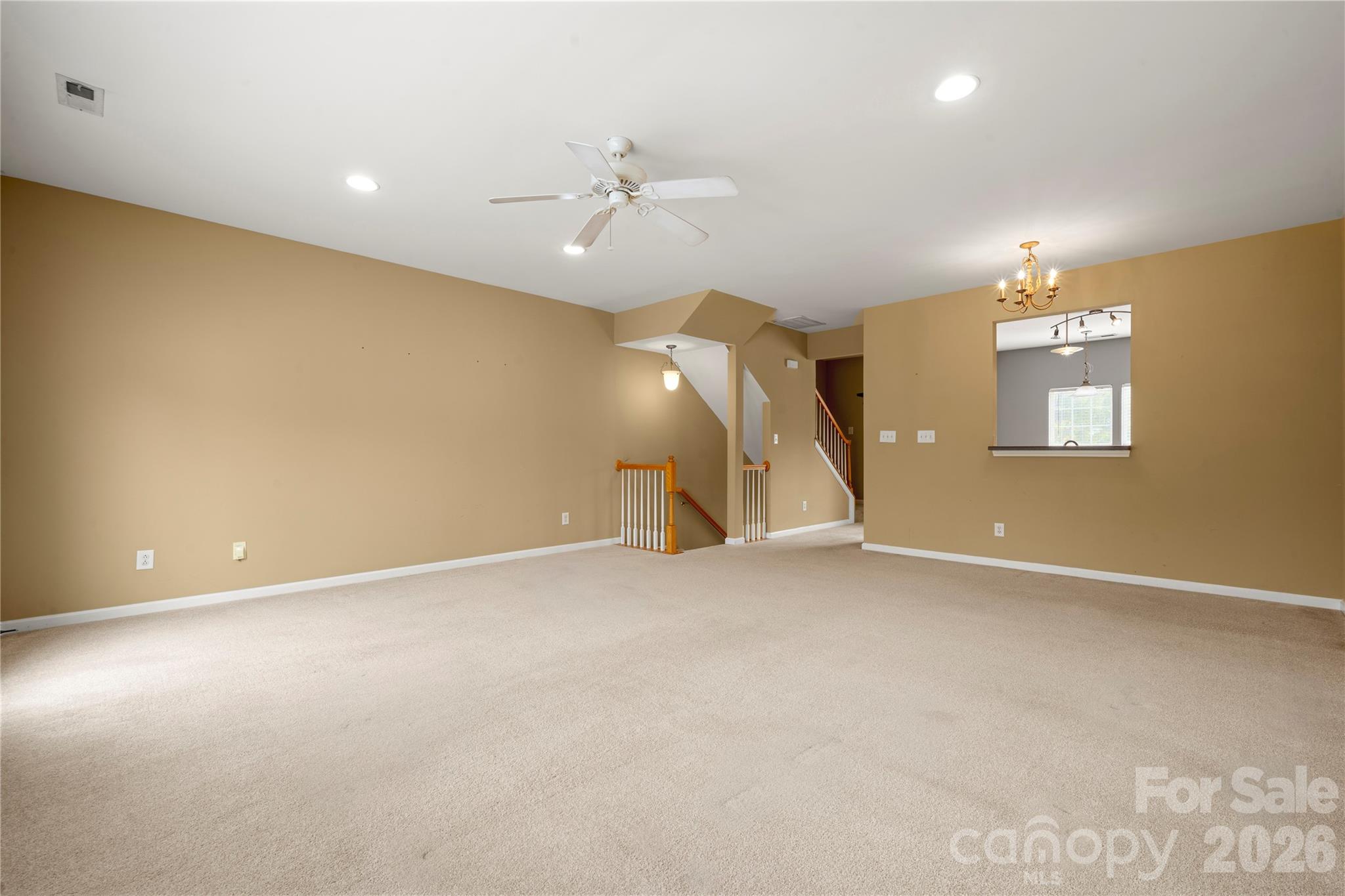10213 Garrett Grigg Road Charlotte, NC 28262 - Photo 9 of 32 an empty room with chandelier fan and windows
