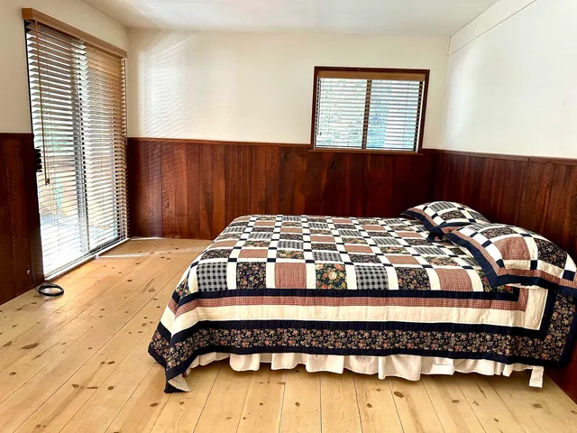 a bedroom with a bed and wooden floor