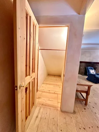 a view of a hallway with wooden floor and staircase