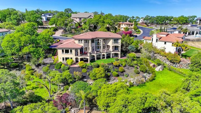 an aerial view of a house with a garden and lake view