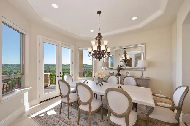 a dining room with furniture a chandelier and wooden floor