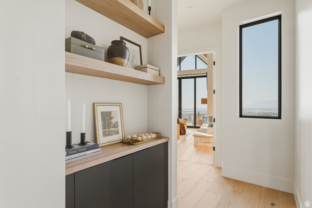 923 North Emery Lane Elk Ridge, UT 84651 - Photo 24 of 101 Open hallway with wood-finish flooring, a tall vertical window, and a built-in cabinet with floating shelves