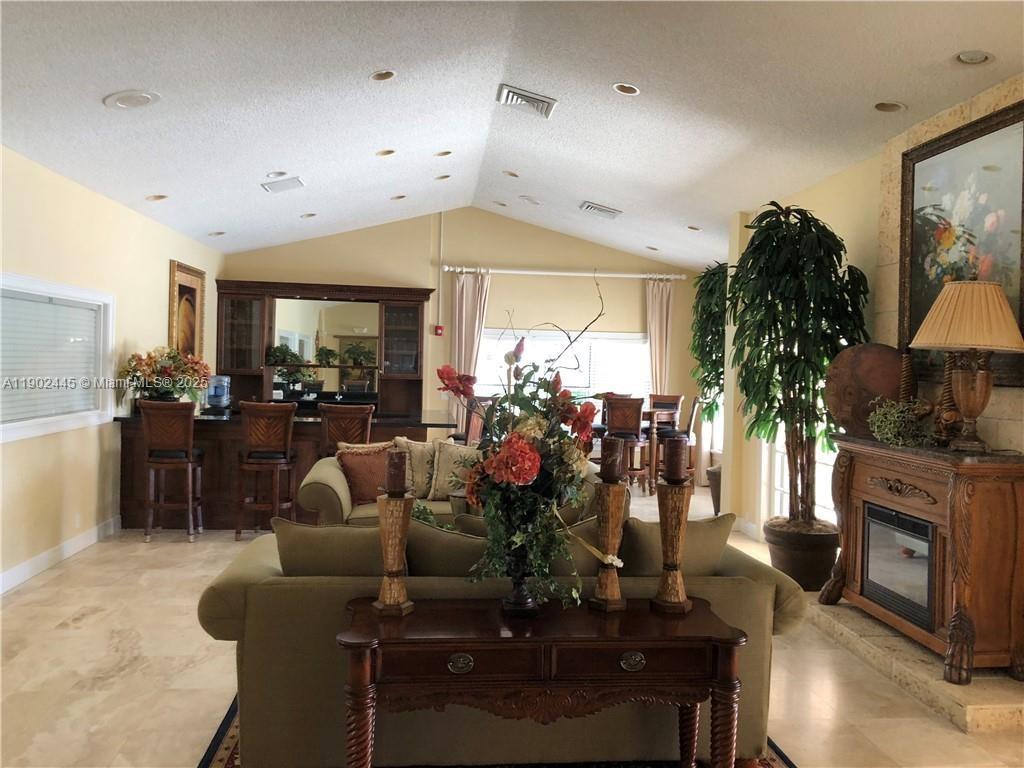 3470 Pinewalk Drive North, Unit 224 Margate, FL 33063 - Photo 18 of 24 a living room with furniture a chandelier and a fireplace