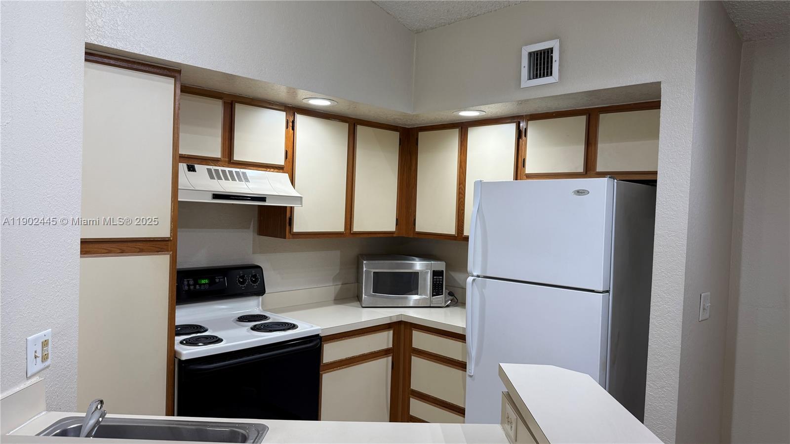3470 Pinewalk Drive North, Unit 224 Margate, FL 33063 - Photo 4 of 24 a kitchen with stainless steel appliances granite countertop a refrigerator a stove a sink dishwasher and a microwave oven