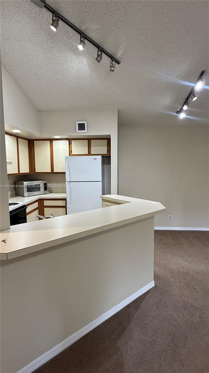 3470 Pinewalk Drive North, Unit 224 Margate, FL 33063 - Photo 5 of 24 a kitchen with kitchen island a counter top and stove
