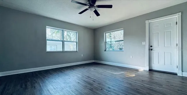 a view of a hallway with wooden floor and staircase