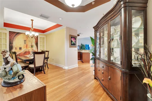 a dining room with wooden floor and large windows