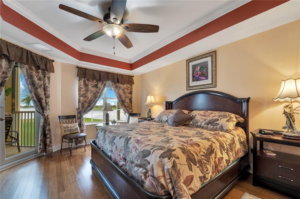 6350 Water Crest Way, Unit 203 Lakewood Ranch, FL 34202 - Photo 20 of 45 a bedroom with a bed and a chandelier