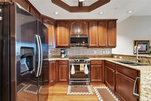 a kitchen with stainless steel appliances granite countertop a stove a sink and a microwave