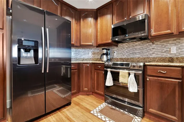 a kitchen with stainless steel appliances granite countertop a stove a refrigerator and a microwave