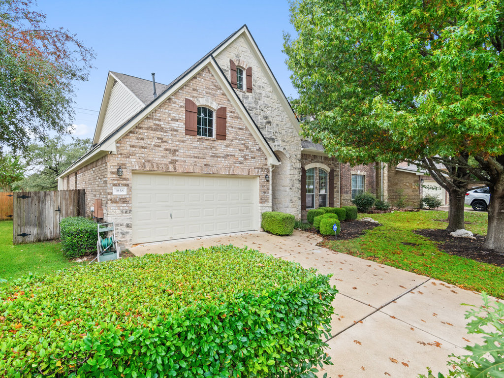 View of front of property featuring brick siding and concrete driveway