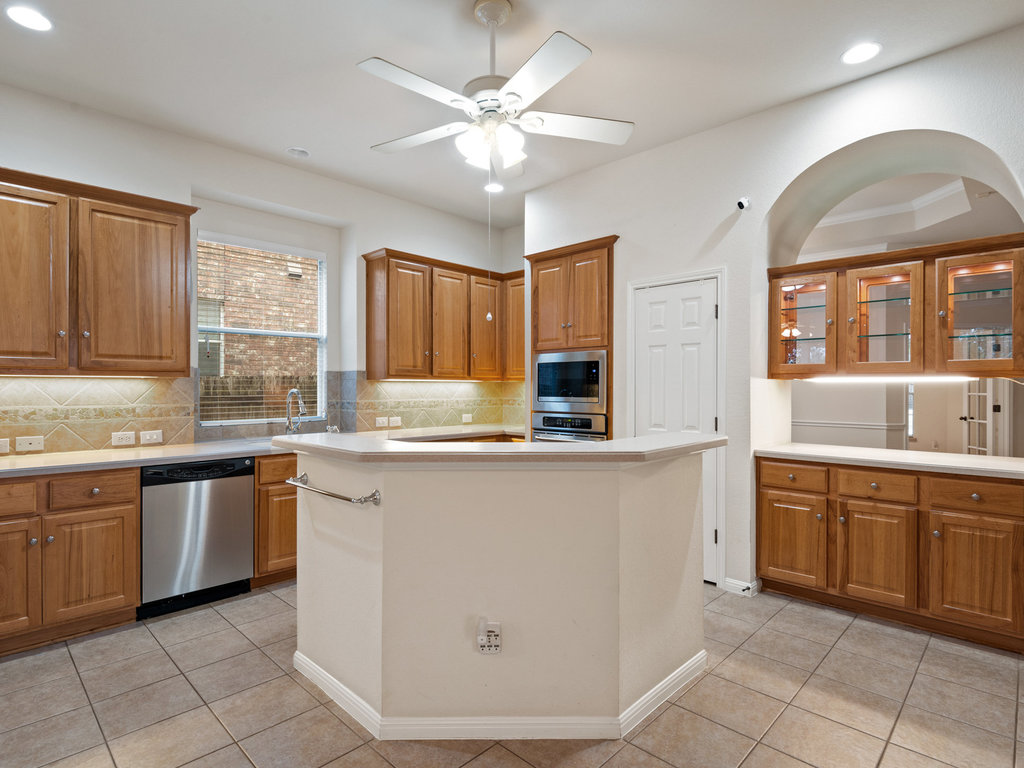 1858 Nelson Ranch Loop Cedar Park, TX 78613 - Photo 11 of 32 Kitchen featuring light countertops, brown cabinets, light tile patterned flooring, and recessed lighting