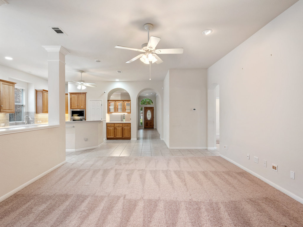 1858 Nelson Ranch Loop Cedar Park, TX 78613 - Photo 2 of 32 Unfurnished living room with arched walkways, light carpet, ceiling fan, light tile patterned floors, and recessed lighting