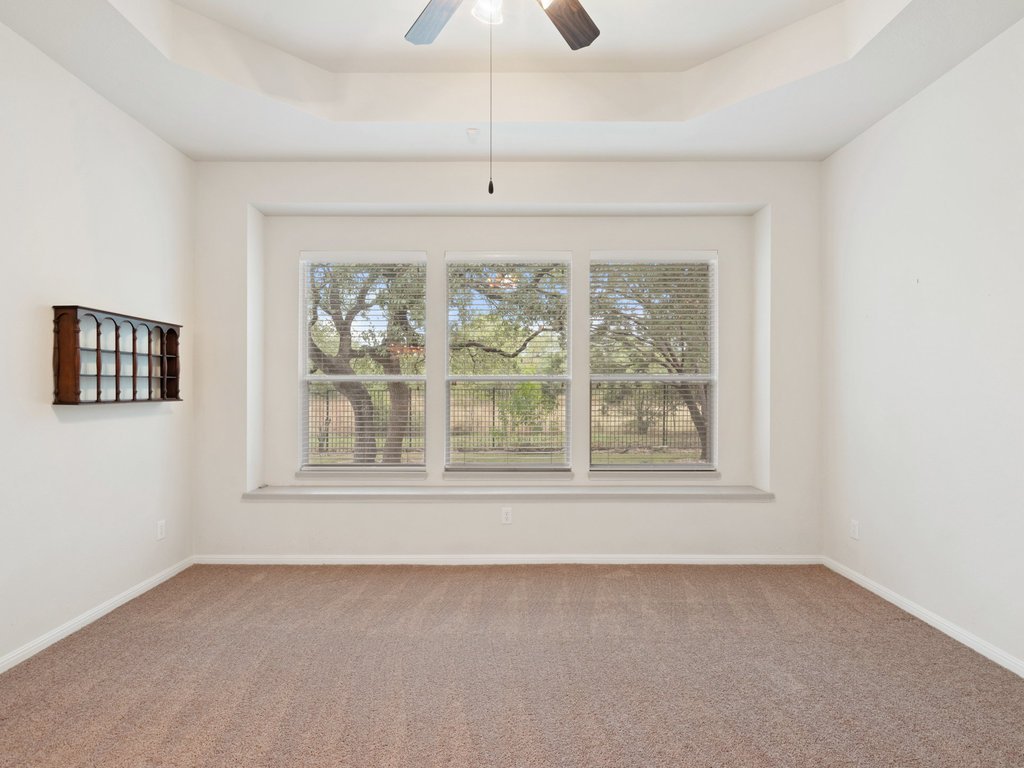 1858 Nelson Ranch Loop Cedar Park, TX 78613 - Photo 24 of 32 Spare room featuring carpet floors, a tray ceiling, and a ceiling fan