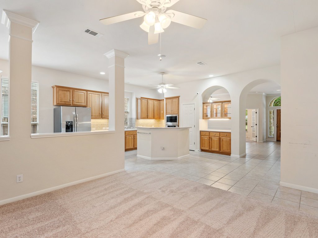 1858 Nelson Ranch Loop Cedar Park, TX 78613 - Photo 3 of 32 Unfurnished living room featuring healthy amount of natural light, arched walkways, ornate columns, light tile patterned floors, and recessed lighting