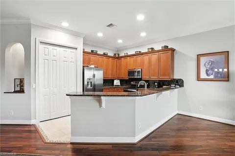 a kitchen with stainless steel appliances granite countertop a sink a stove and a refrigerator