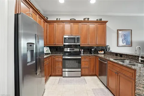 a kitchen with granite countertop a refrigerator and a sink