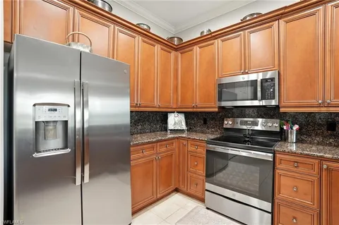 a kitchen with stainless steel appliances granite countertop a refrigerator and a stove top oven