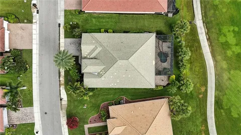 a view of a big house with a big yard and potted plants